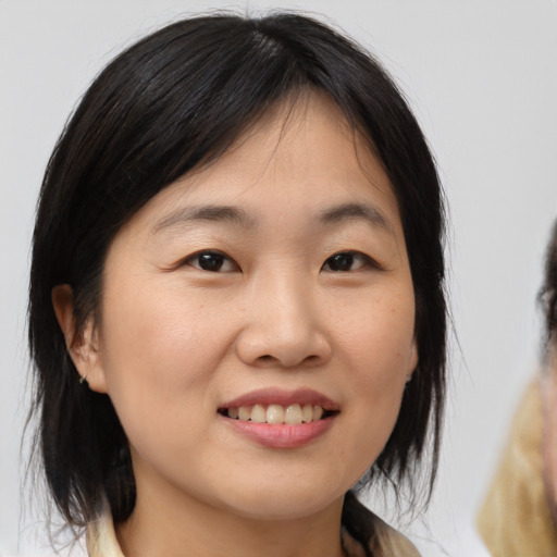 Joyful asian young-adult female with medium  brown hair and brown eyes