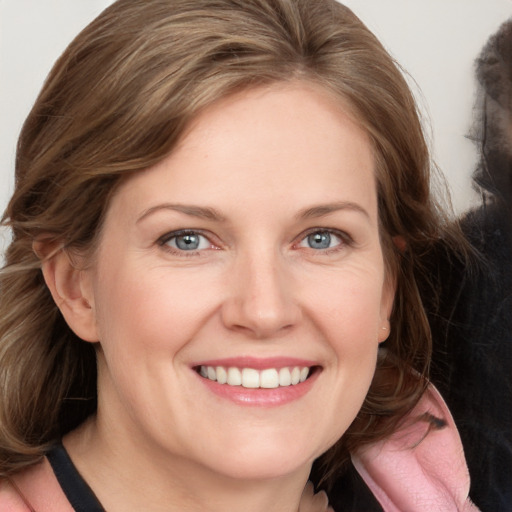 Joyful white adult female with medium  brown hair and blue eyes