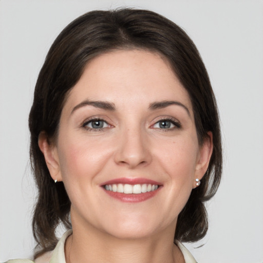 Joyful white young-adult female with medium  brown hair and grey eyes