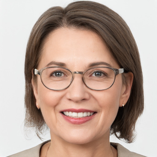 Joyful white adult female with medium  brown hair and grey eyes