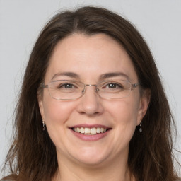 Joyful white adult female with long  brown hair and grey eyes