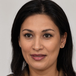 Joyful latino adult female with medium  brown hair and brown eyes