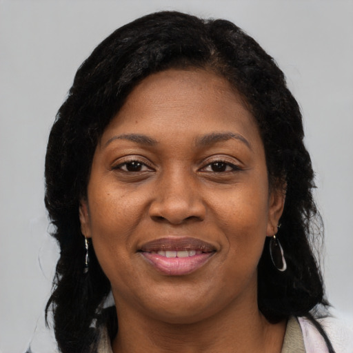 Joyful black adult female with long  black hair and brown eyes