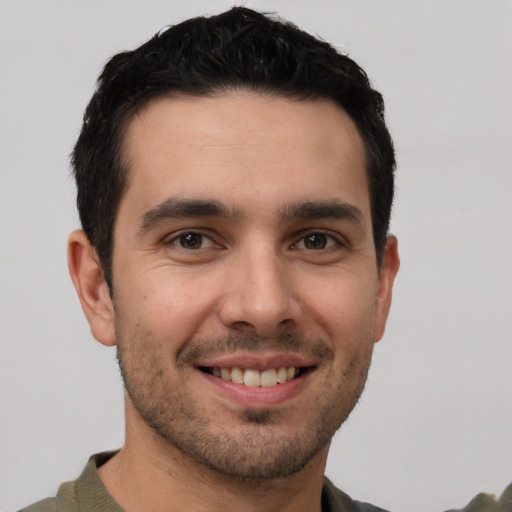 Joyful white young-adult male with short  black hair and brown eyes