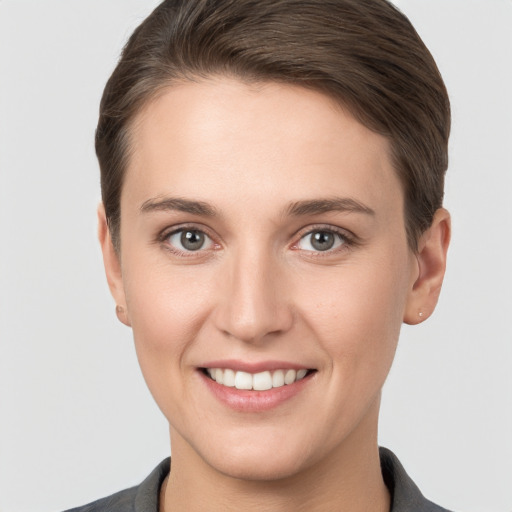 Joyful white young-adult female with short  brown hair and grey eyes