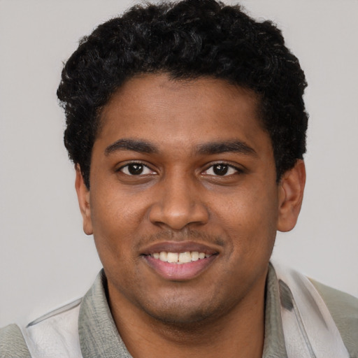 Joyful black young-adult male with short  black hair and brown eyes