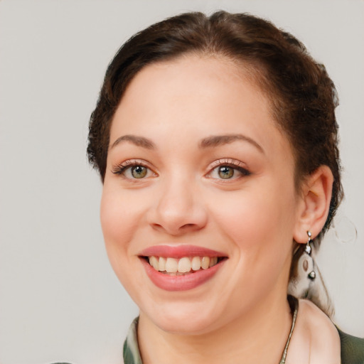 Joyful white young-adult female with medium  brown hair and green eyes