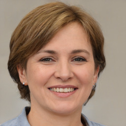 Joyful white adult female with medium  brown hair and brown eyes