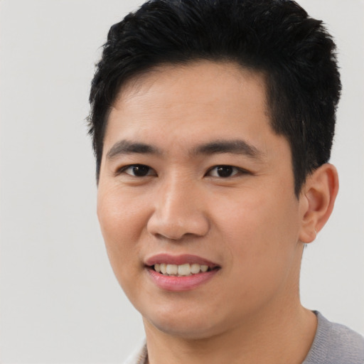 Joyful asian young-adult male with short  black hair and brown eyes