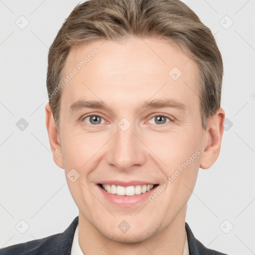 Joyful white young-adult male with short  brown hair and grey eyes