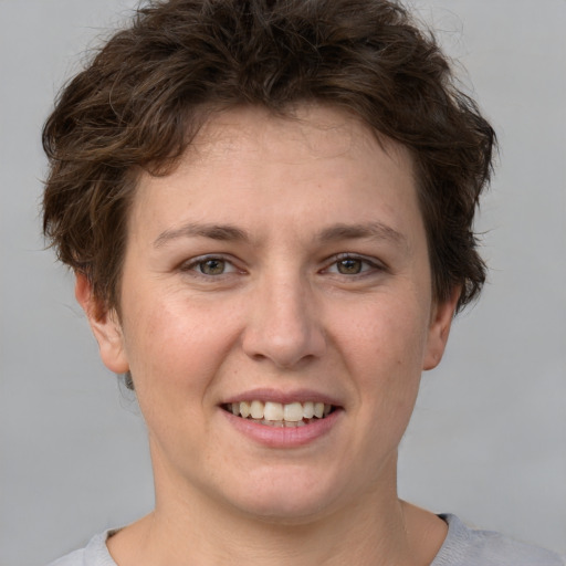 Joyful white young-adult female with short  brown hair and grey eyes