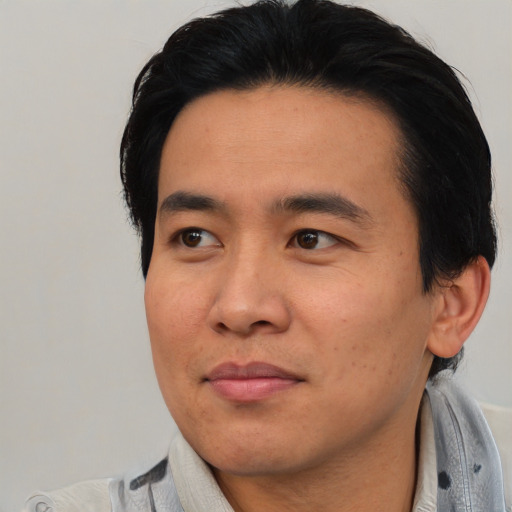 Joyful asian young-adult male with short  black hair and brown eyes