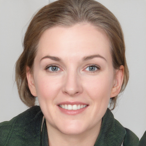 Joyful white young-adult female with medium  brown hair and green eyes