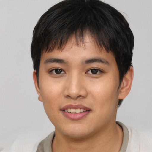 Joyful asian young-adult male with short  black hair and brown eyes
