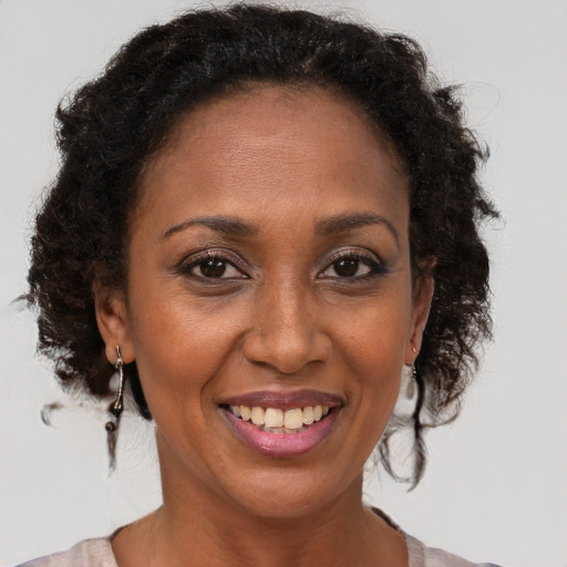 Joyful black adult female with medium  brown hair and brown eyes