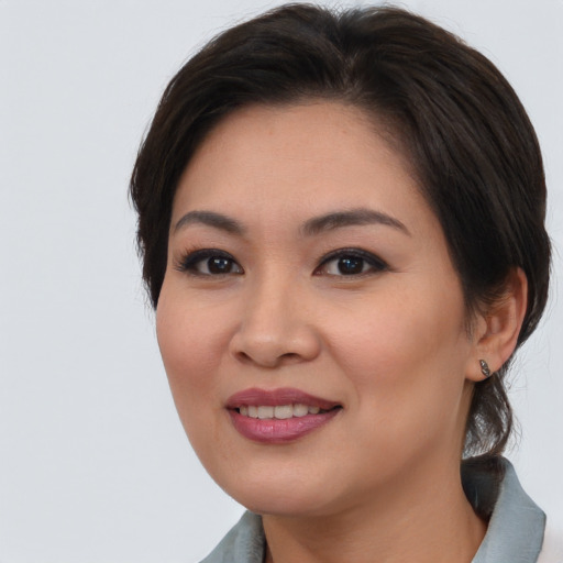 Joyful asian young-adult female with medium  brown hair and brown eyes