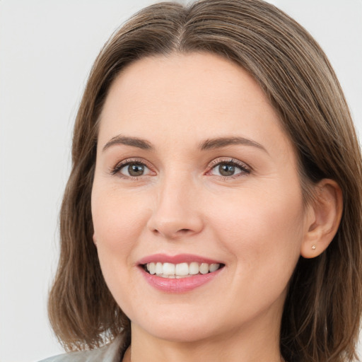 Joyful white young-adult female with medium  brown hair and grey eyes