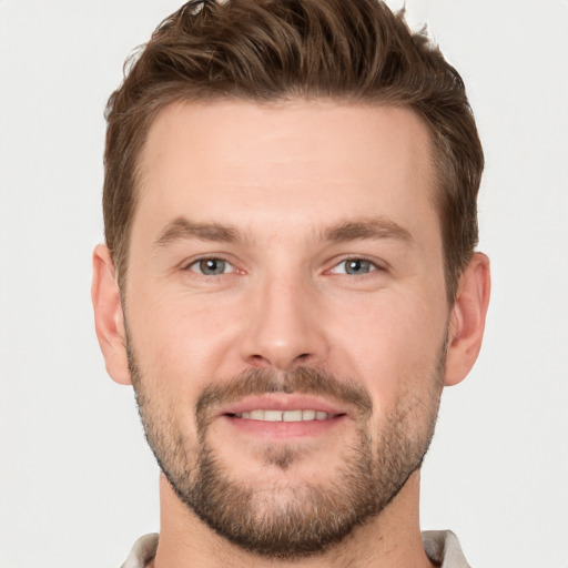 Joyful white young-adult male with short  brown hair and grey eyes