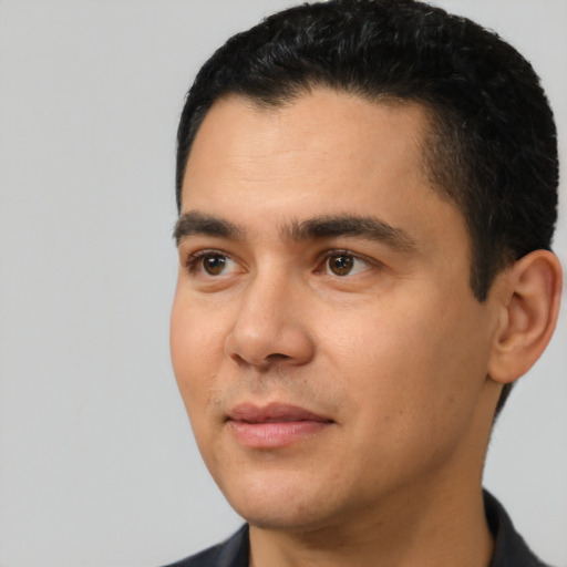 Joyful latino young-adult male with short  black hair and brown eyes