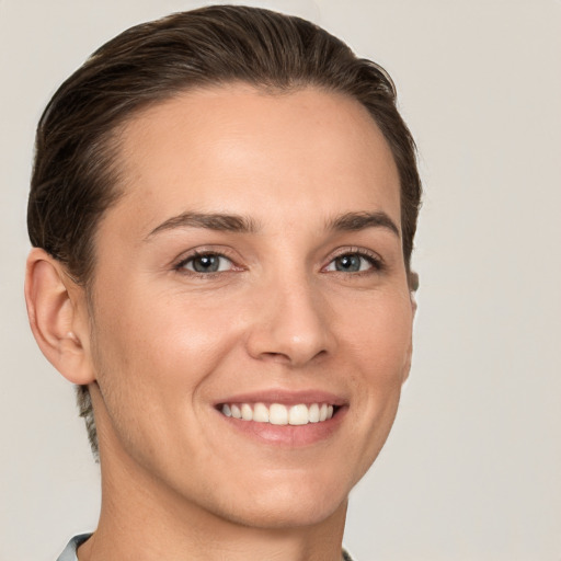 Joyful white young-adult female with short  brown hair and grey eyes