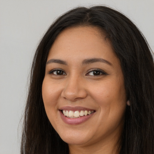 Joyful latino young-adult female with long  brown hair and brown eyes