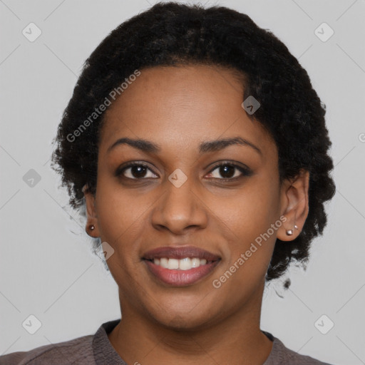 Joyful black young-adult female with short  black hair and brown eyes