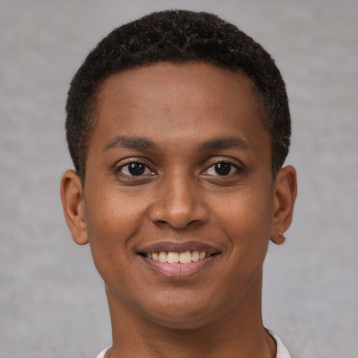 Joyful black young-adult male with short  brown hair and brown eyes