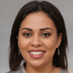 Joyful latino young-adult female with long  brown hair and brown eyes