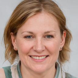 Joyful white adult female with medium  brown hair and blue eyes