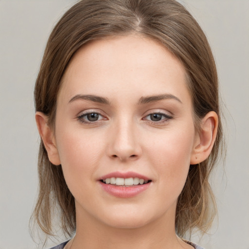 Joyful white young-adult female with medium  brown hair and grey eyes