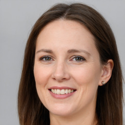 Joyful white young-adult female with long  brown hair and grey eyes