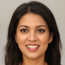 Joyful latino young-adult female with long  brown hair and brown eyes