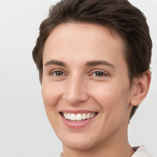 Joyful white young-adult female with short  brown hair and grey eyes