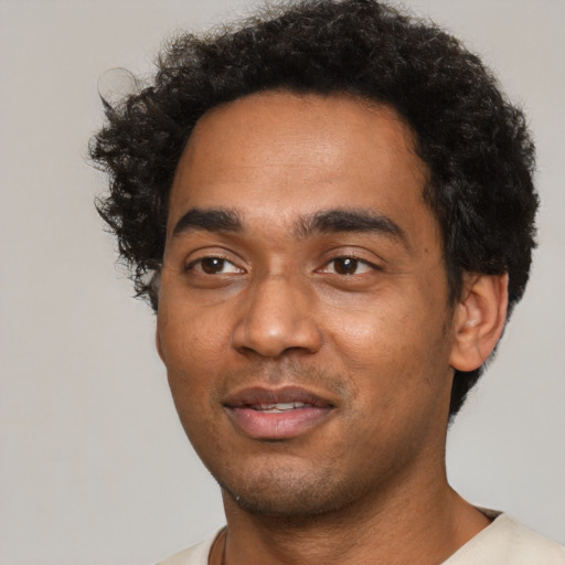 Joyful black young-adult male with short  black hair and brown eyes