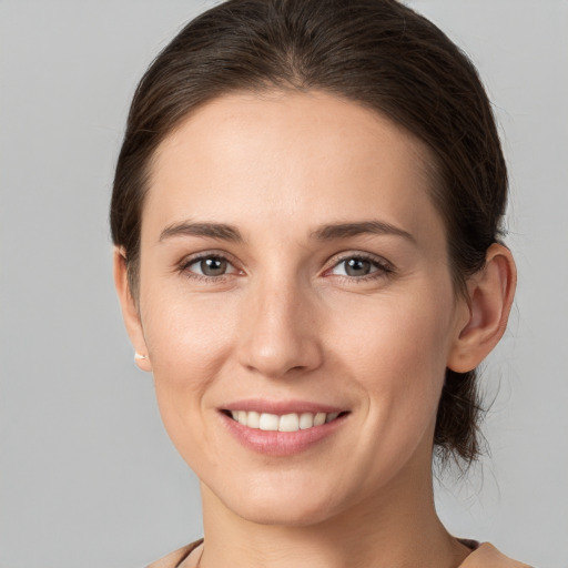 Joyful white young-adult female with medium  brown hair and grey eyes