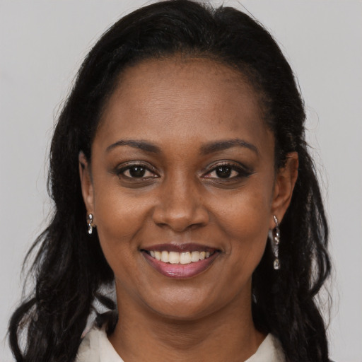 Joyful black young-adult female with long  brown hair and brown eyes