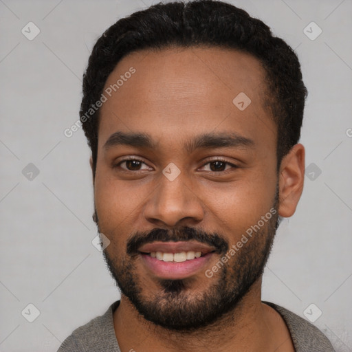 Joyful black young-adult male with short  black hair and brown eyes