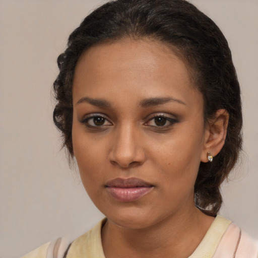 Joyful black young-adult female with medium  brown hair and brown eyes