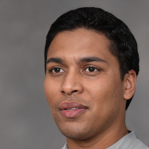 Joyful latino young-adult male with short  black hair and brown eyes