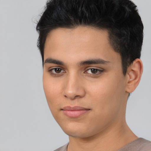 Joyful latino young-adult male with short  brown hair and brown eyes