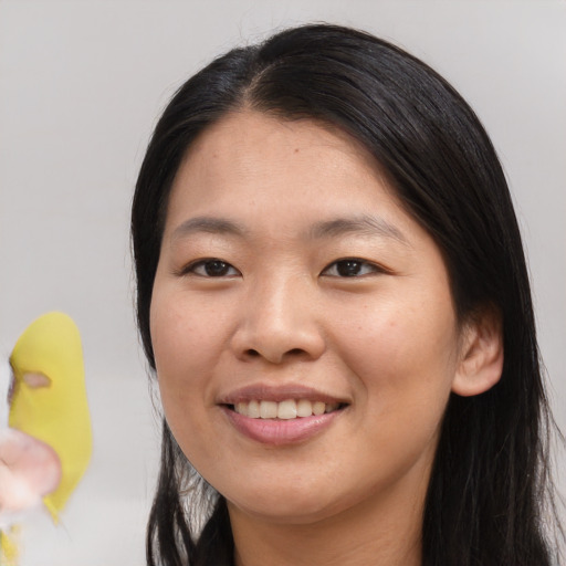 Joyful asian young-adult female with long  black hair and brown eyes