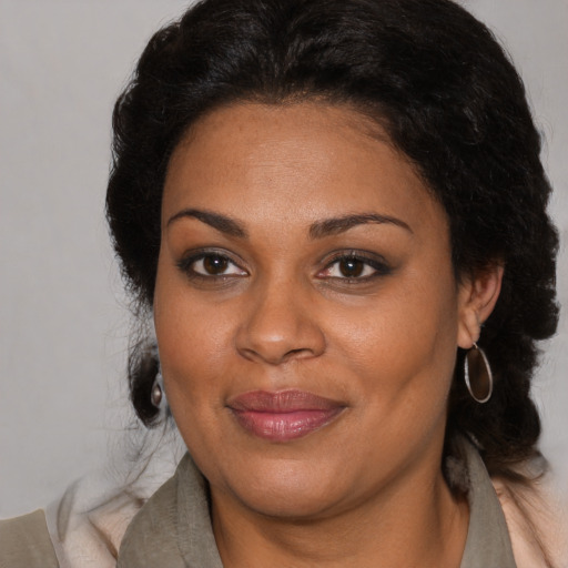 Joyful black adult female with medium  brown hair and brown eyes