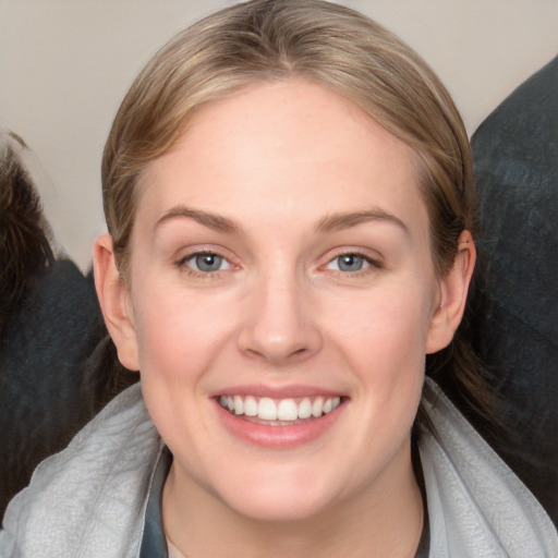 Joyful white young-adult female with medium  brown hair and blue eyes