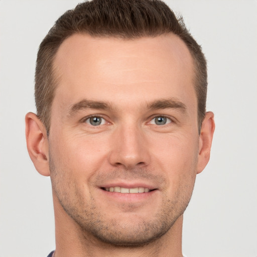 Joyful white young-adult male with short  brown hair and grey eyes