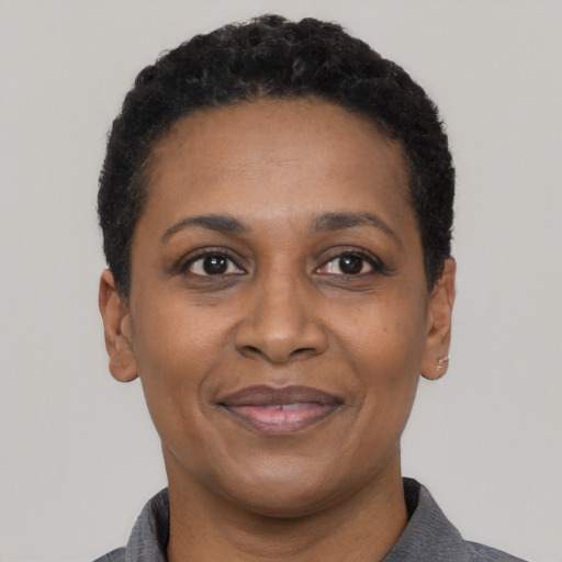 Joyful black adult female with short  black hair and brown eyes