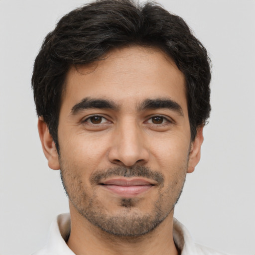 Joyful latino young-adult male with short  black hair and brown eyes