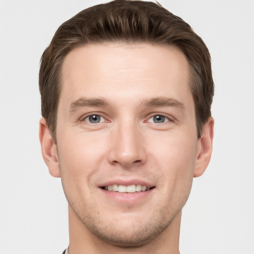 Joyful white young-adult male with short  brown hair and grey eyes