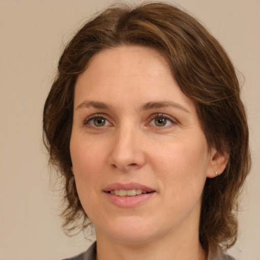 Joyful white adult female with medium  brown hair and green eyes