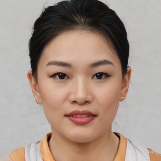 Joyful asian young-adult female with short  brown hair and brown eyes