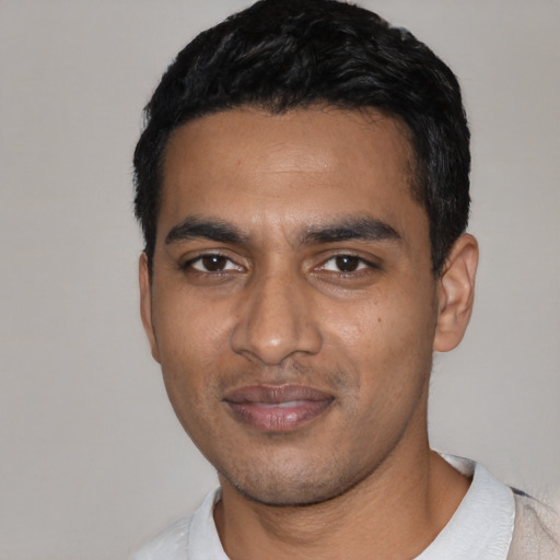 Joyful black young-adult male with short  black hair and brown eyes